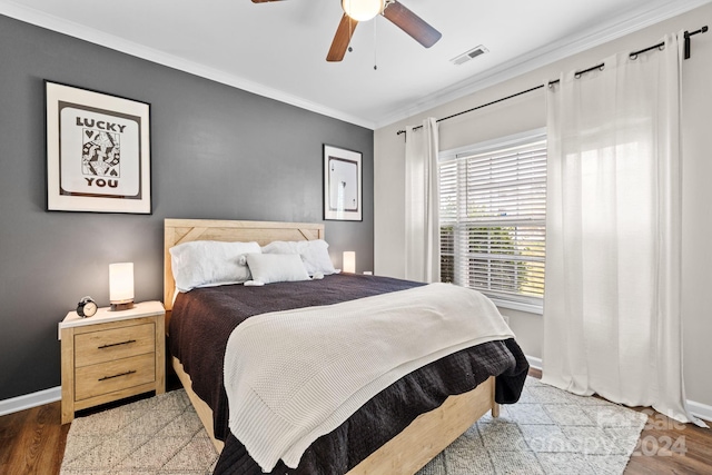 bedroom with dark hardwood / wood-style floors, ceiling fan, and ornamental molding