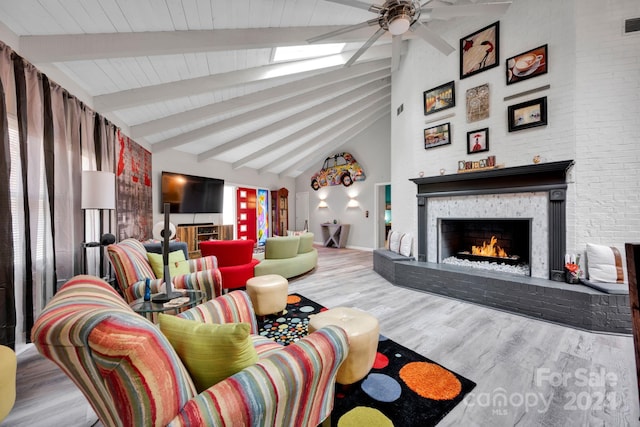 living room with beam ceiling, ceiling fan, high vaulted ceiling, brick wall, and wood-type flooring