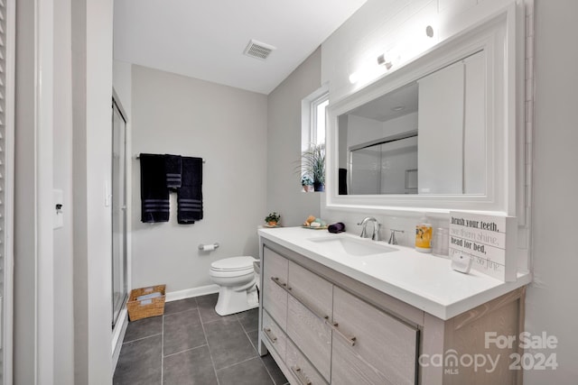 bathroom featuring tasteful backsplash, tile patterned floors, vanity, a shower with door, and toilet