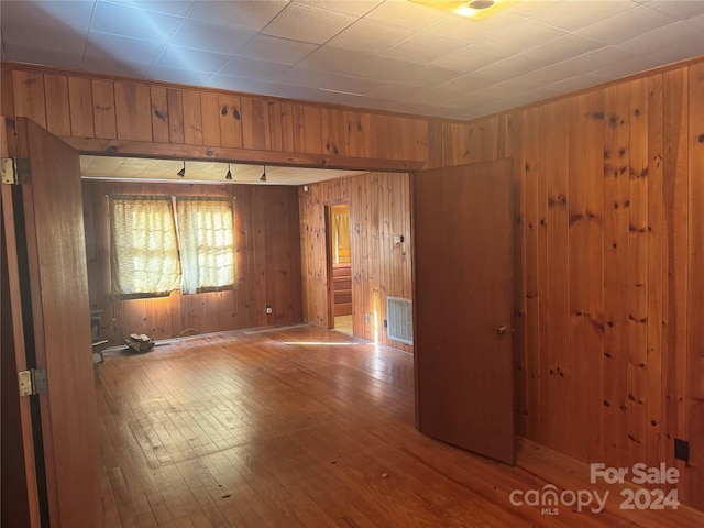 empty room featuring wooden walls and light hardwood / wood-style flooring