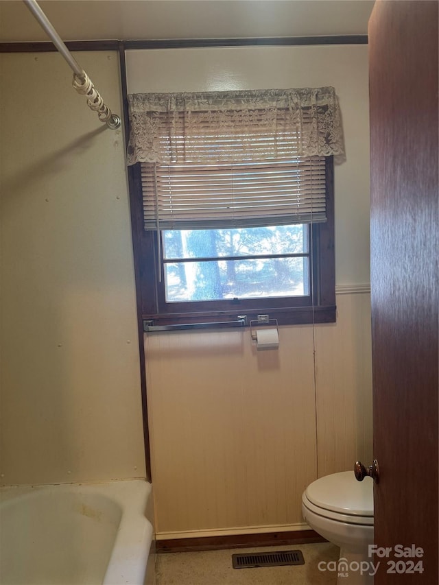 bathroom with wooden walls and toilet