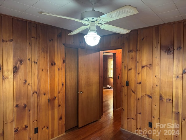 hallway featuring hardwood / wood-style flooring and wood walls