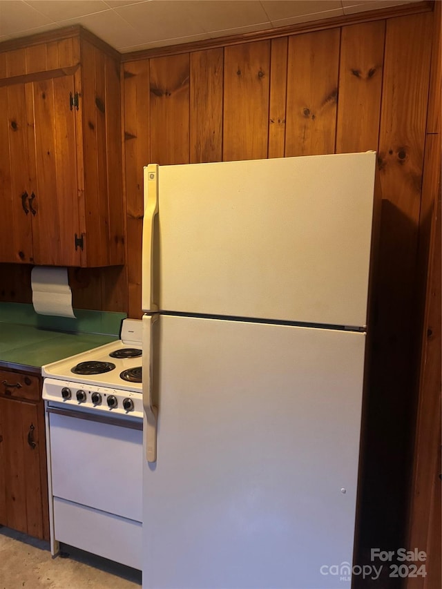 kitchen featuring white appliances and wooden walls