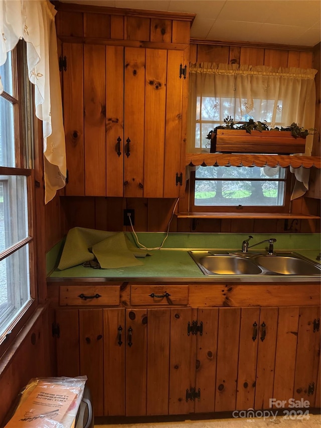 kitchen featuring wood walls and sink