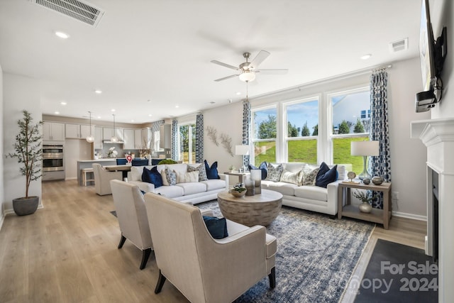 living room featuring ceiling fan and light wood-type flooring