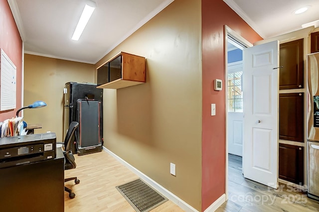 home office featuring ornamental molding and light hardwood / wood-style flooring