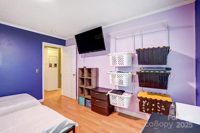 bedroom featuring crown molding and light wood-type flooring