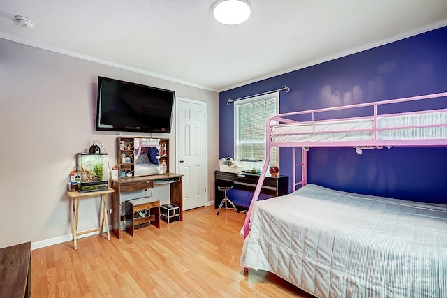 bedroom with ornamental molding and wood-type flooring