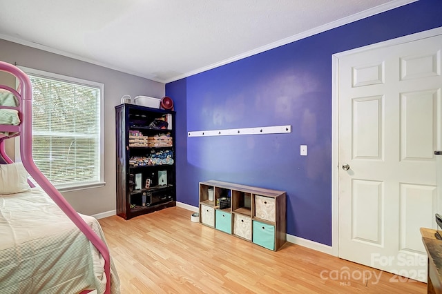 bedroom with wood-type flooring and ornamental molding