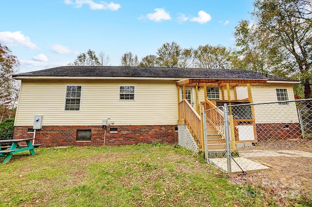 rear view of property featuring a lawn