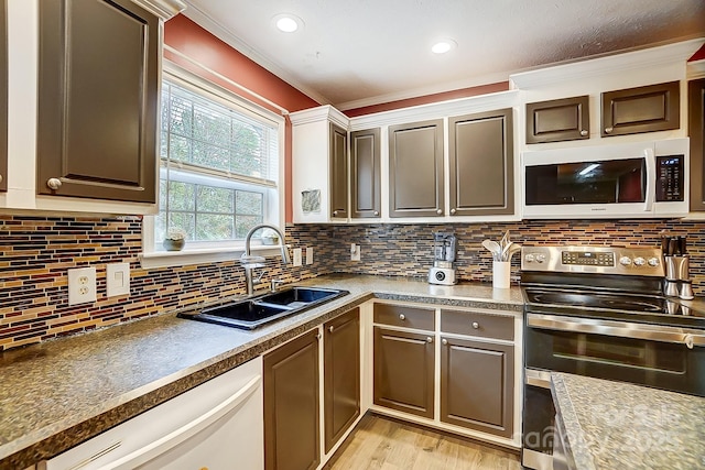 kitchen featuring sink, decorative backsplash, white appliances, and light wood-type flooring