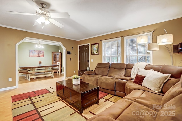 living room with crown molding, ceiling fan with notable chandelier, and light hardwood / wood-style floors