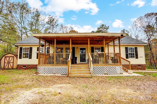 rear view of house featuring a storage shed and covered porch