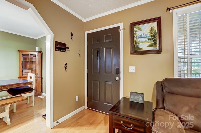 entrance foyer featuring ornamental molding and light wood-type flooring