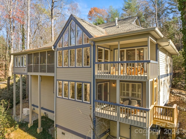 rear view of property featuring a sunroom and a balcony