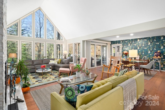 living room featuring hardwood / wood-style flooring, a healthy amount of sunlight, and high vaulted ceiling