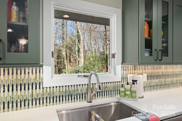 details featuring light stone countertops, green cabinets, and sink