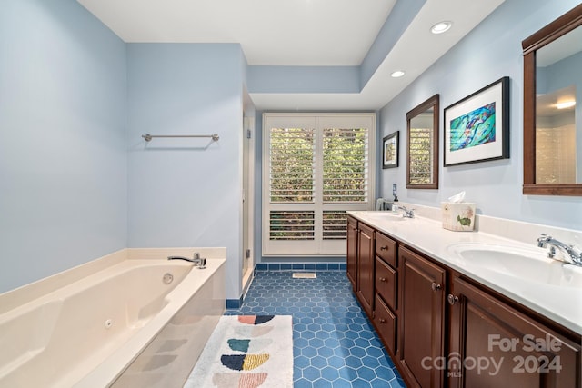 bathroom with tile patterned flooring, vanity, and a bathing tub