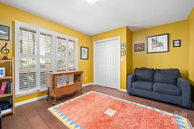 living area with a textured ceiling and dark hardwood / wood-style flooring