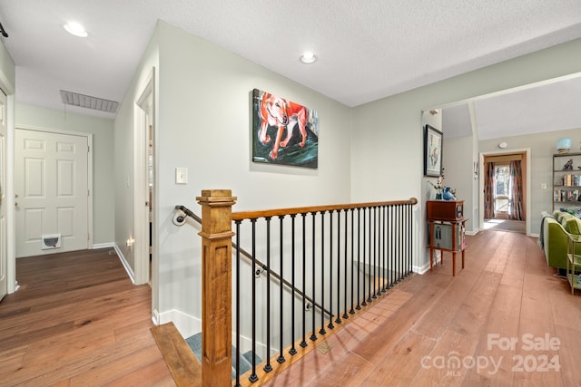 hall featuring hardwood / wood-style flooring and a textured ceiling