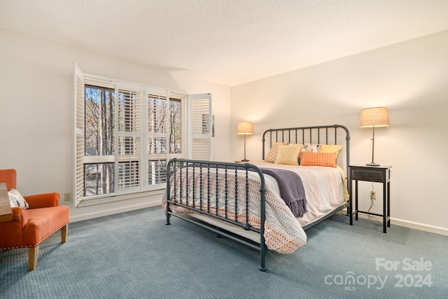 bedroom featuring a textured ceiling and carpet floors