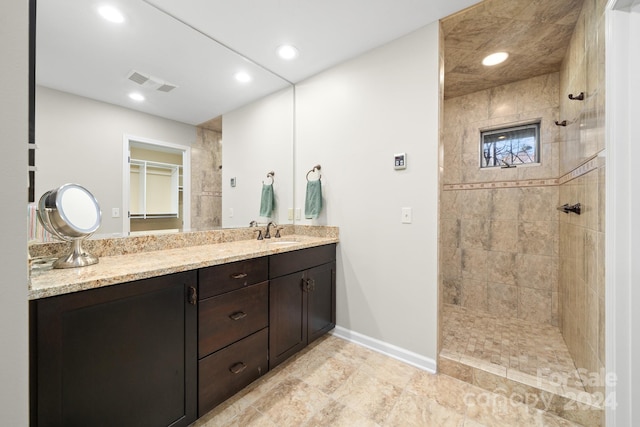 bathroom with vanity and tiled shower