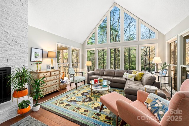 sunroom / solarium with a fireplace and vaulted ceiling