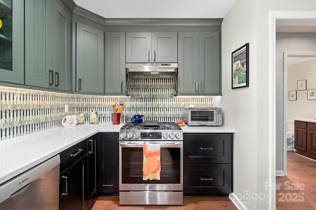 kitchen featuring appliances with stainless steel finishes, light hardwood / wood-style floors, and decorative backsplash