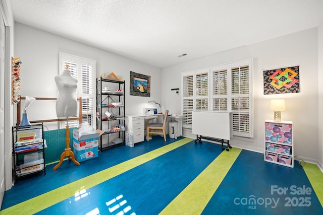 recreation room with a textured ceiling