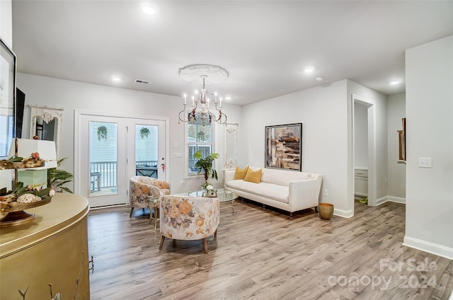 living room with light hardwood / wood-style flooring and a chandelier