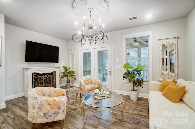 living room featuring a premium fireplace, a chandelier, and dark hardwood / wood-style floors