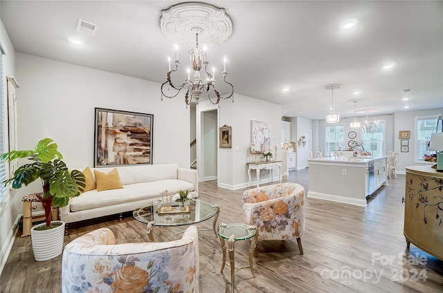 living room with light hardwood / wood-style floors and a chandelier