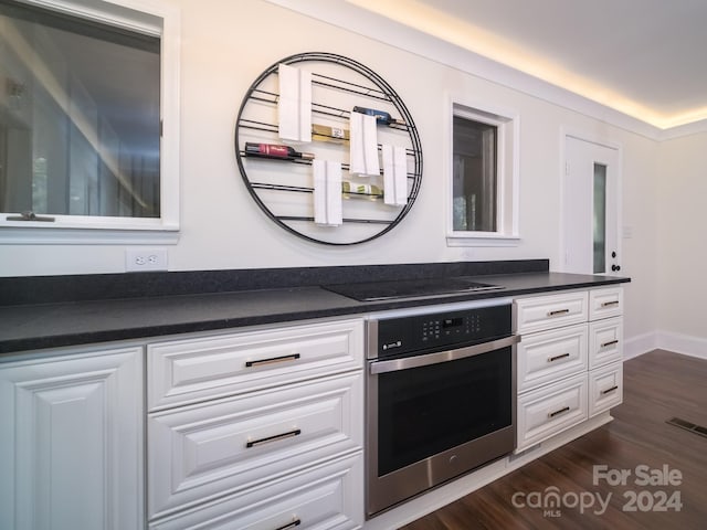 kitchen featuring white cabinets, dark hardwood / wood-style floors, oven, and black electric cooktop