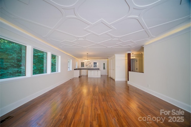 unfurnished living room featuring an ornate ceiling, visible vents, baseboards, and wood finished floors