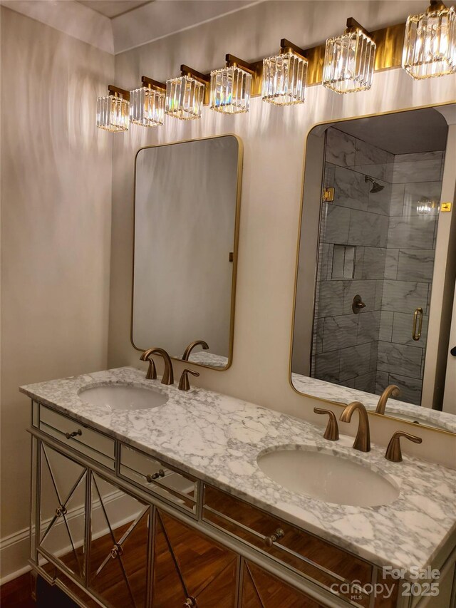 full bathroom with double vanity, a sink, and a shower stall