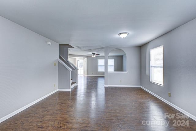 unfurnished living room with dark hardwood / wood-style floors and ceiling fan