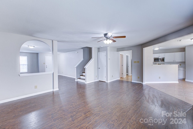 unfurnished living room featuring dark hardwood / wood-style flooring and ceiling fan