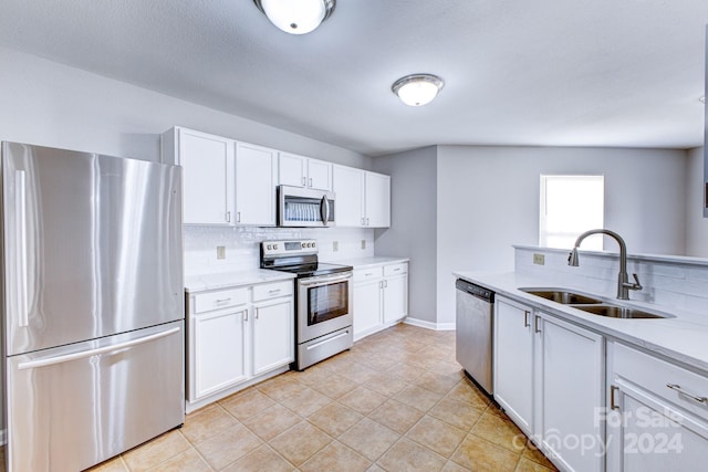 kitchen featuring decorative backsplash, sink, white cabinets, and stainless steel appliances