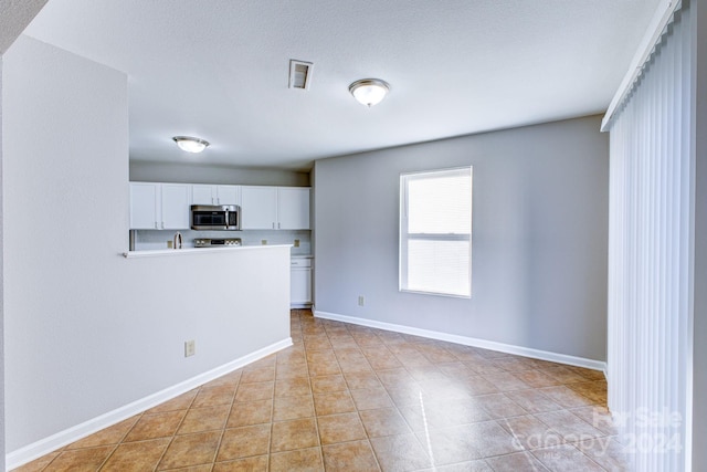 kitchen featuring white cabinetry and light tile patterned floors