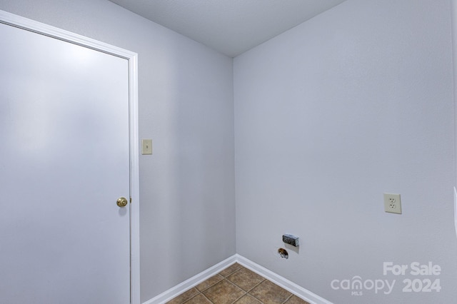 laundry area featuring dark tile patterned floors