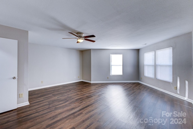 unfurnished room with a textured ceiling, dark hardwood / wood-style floors, and ceiling fan