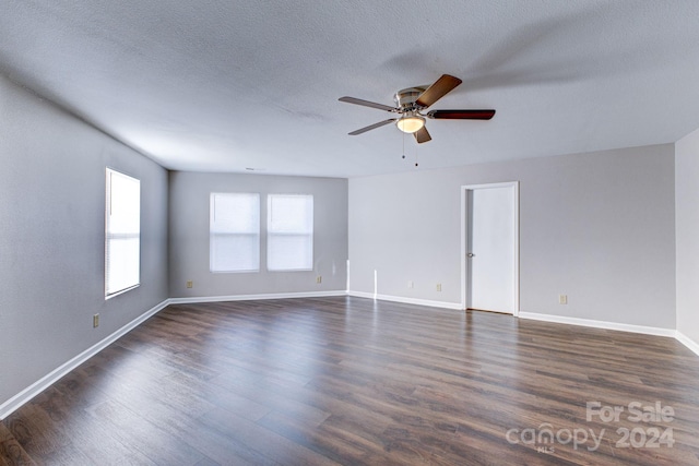 spare room featuring ceiling fan, dark hardwood / wood-style flooring, and a textured ceiling