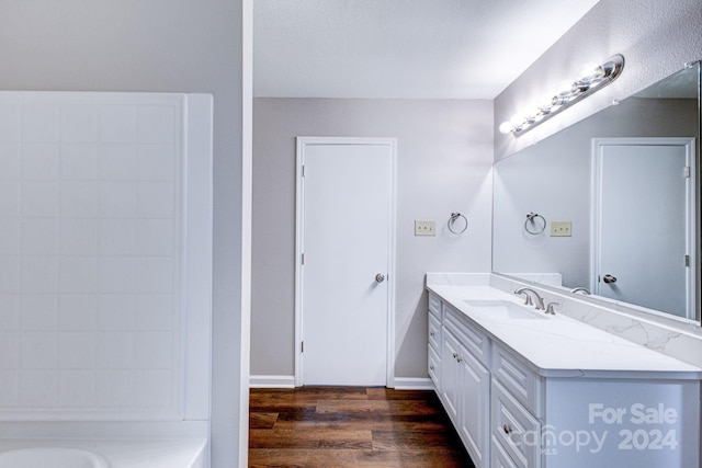 bathroom with a bathtub, vanity, and hardwood / wood-style flooring