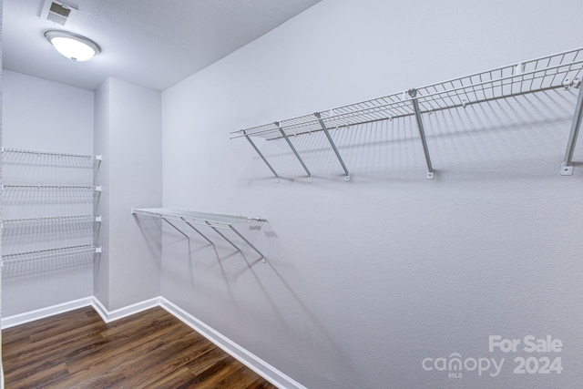 spacious closet with dark hardwood / wood-style floors