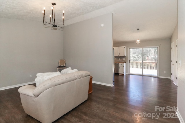 living room with dark wood-type flooring and a notable chandelier