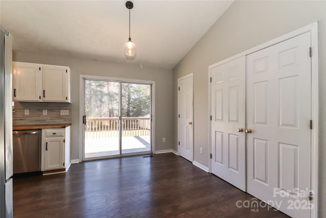 unfurnished dining area with vaulted ceiling and dark hardwood / wood-style floors