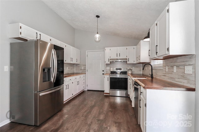 kitchen featuring white cabinetry, stainless steel appliances, decorative light fixtures, and sink