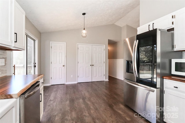 kitchen featuring butcher block countertops, white cabinetry, appliances with stainless steel finishes, dark hardwood / wood-style floors, and pendant lighting