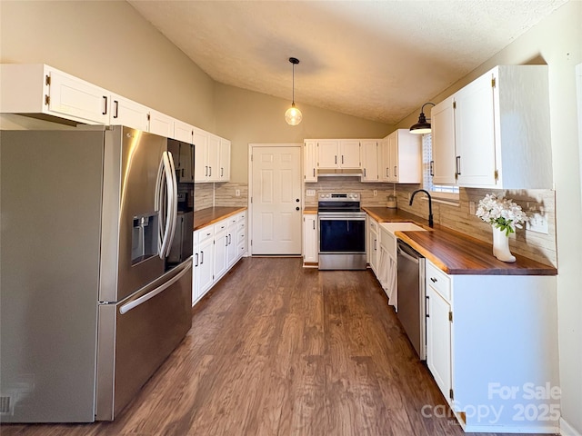 kitchen with stainless steel appliances, dark wood-type flooring, a sink, vaulted ceiling, and decorative backsplash