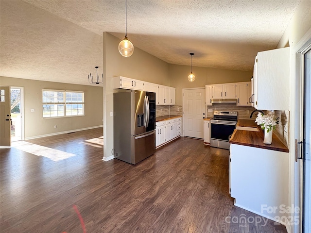 kitchen with dark wood-style flooring, appliances with stainless steel finishes, vaulted ceiling, wood counters, and a sink